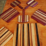 A beautiful array of cutting boards - notice some have handles, others have a curved edge, and others are rectangular